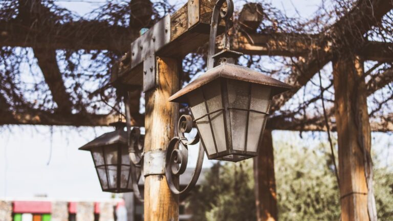 Pergola en bois éclairée par des guirlandes lumineuses le soir
